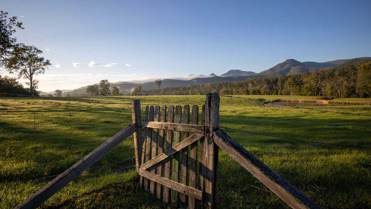 A picture of a wooden fence against a green field