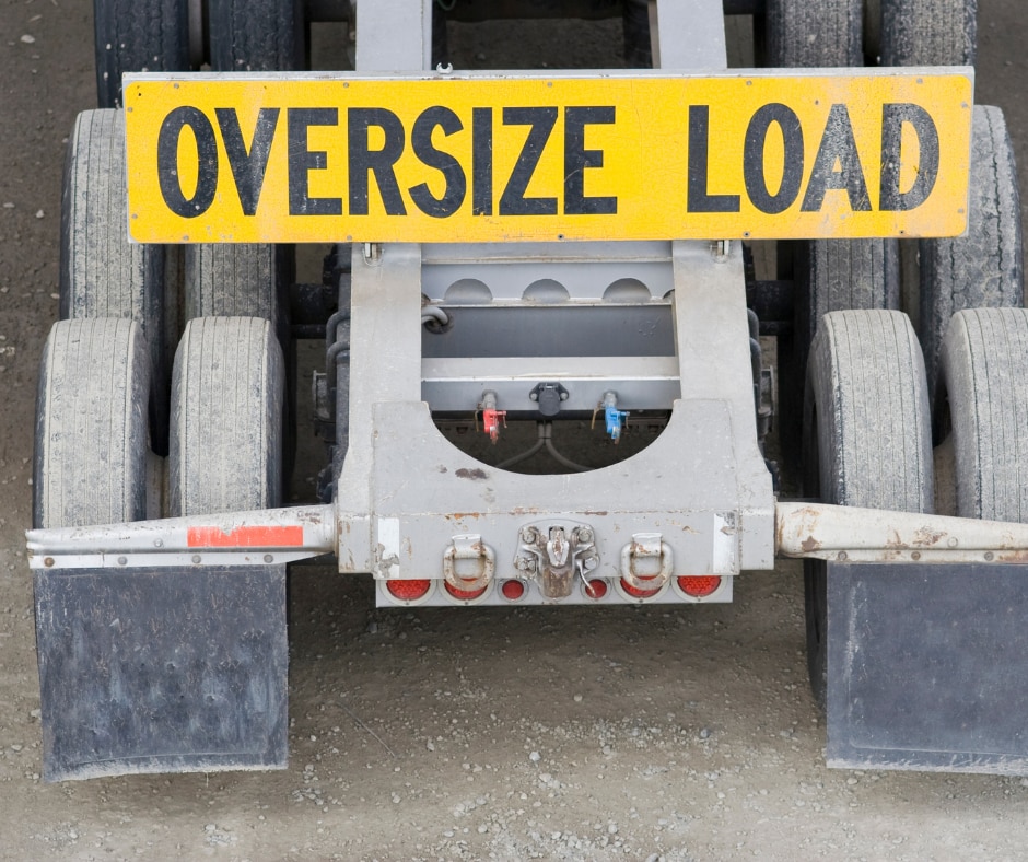 A photo of the rear of a truck trailer with an 'Oversize Load' sign on it